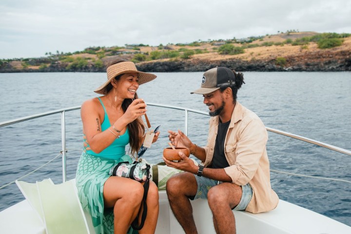 a man and a woman sitting in a boat on a body of water